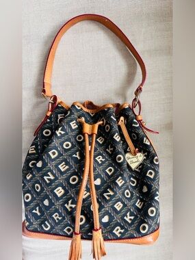 Isn’t She Pretty! 😍 Dooney & Bourke Large Crossword Drawstring Bucket Bag